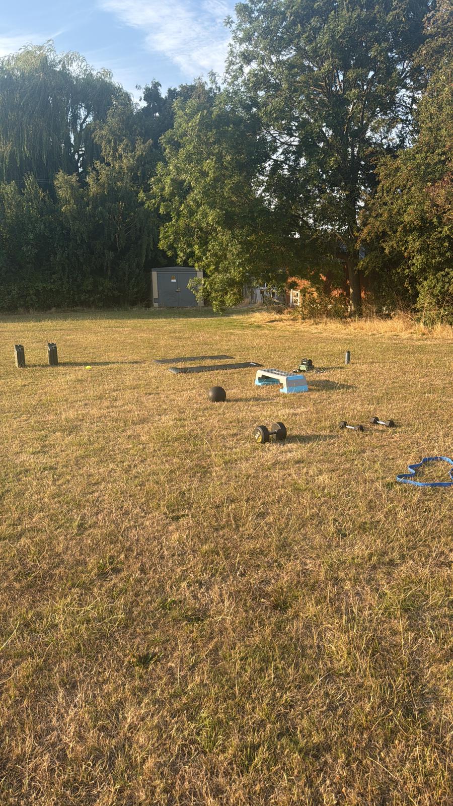 Outdoor bootcamp equipment set up in a field at dusk